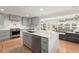 Open concept kitchen with island, stainless steel appliances, custom cabinets, quartz countertops, and hardwood floors at 1673 Mcclain St, Charleston, SC 29407