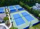 Aerial view of tennis courts in a wooded community, surrounded by green trees and a small lake at 1678 William Hapton Way, Mount Pleasant, SC 29466