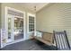 The porch has a cozy swing and view into the entry with a decorative glass door at 1678 William Hapton Way, Mount Pleasant, SC 29466
