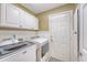 Functional laundry room with white cabinets, modern appliances, and access door to the exterior at 1678 William Hapton Way, Mount Pleasant, SC 29466