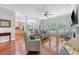 Bright open-concept living room featuring hardwood floors, a ceiling fan, and large windows providing ample natural light at 1678 William Hapton Way, Mount Pleasant, SC 29466