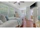 Sunlit main bedroom featuring wood floors, multiple windows, and an ensuite bathroom for added privacy and convenience at 1678 William Hapton Way, Mount Pleasant, SC 29466
