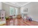 A bright playroom with hardwood floors and two windows that let in lots of natural light at 1678 William Hapton Way, Mount Pleasant, SC 29466