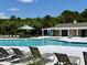 Community pool with lounge chairs, shaded seating, and a nearby pool house, perfect for relaxation and recreation at 1678 William Hapton Way, Mount Pleasant, SC 29466