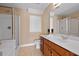 Well-lit bathroom featuring a vanity with sink, toilet, and tiled walk-in shower at 1825 Brittlebush Ln, Johns Island, SC 29455