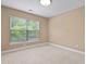 Neutral carpeted bedroom with neutral paint, white trim and large window overlooking trees at 1825 Brittlebush Ln, Johns Island, SC 29455