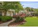 Inviting two-story home featuring a pergola, tidy landscaping, and beautiful pink roses along the walkway at 1825 Brittlebush Ln, Johns Island, SC 29455