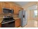 Modern kitchen featuring granite countertops, stainless steel appliances, and wooden cabinetry at 1825 Brittlebush Ln, Johns Island, SC 29455