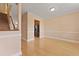 Open-concept living area with hardwood floors, neutral walls, access to kitchen, and a carpeted staircase at 1825 Brittlebush Ln, Johns Island, SC 29455