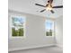 Bright bedroom features neutral walls, carpet flooring, ceiling fan, and two windows with beautiful views at 202 Countryside Way, Summerville, SC 29483