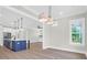 Open dining and kitchen area with view of kitchen island, modern lighting and large windows at 202 Countryside Way, Summerville, SC 29483