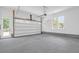 Clean garage with concrete floor, white walls, and natural light from the door and windows at 202 Countryside Way, Summerville, SC 29483