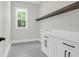 Well-lit laundry room featuring decorative tile flooring, white cabinets and a floating shelf at 202 Countryside Way, Summerville, SC 29483