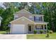 Charming two-story home with a well-manicured lawn, attached garage, and inviting front porch at 206 Trickle Dr, Summerville, SC 29483