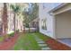 Landscaped backyard features a stone walkway and lush plantings at 2151 River Road, Johns Island, SC 29455