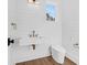 Modern half bath features a floating marble sink, gold fixtures, shiplap walls, and a window offering natural light at 2151 River Road, Johns Island, SC 29455