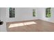 Bright bedroom featuring wood floors and multiple windows bringing in plenty of natural light at 2151 River Road, Johns Island, SC 29455