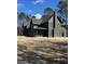View of newly constructed modern two-story home, displaying a dark exterior, chimney, and unfinished yard at 2151 River Road, Johns Island, SC 29455