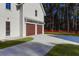 Exterior view of a modern home with a white facade and brown wood double garage door at 2151 River Road, Johns Island, SC 29455