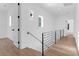 Upstairs hallway with wood floors, metal railing, white walls, and a window allowing natural light at 2151 River Road, Johns Island, SC 29455