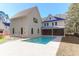 Back of a white home with a serene backyard pool and paved patio at 2151 River Road, Johns Island, SC 29455