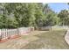 Large backyard with a trampoline and ample green space, surrounded by a white picket fence at 2197 Sandy Point Ln, Mount Pleasant, SC 29466