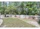 Spacious backyard with a fire pit area, surrounded by lush landscaping and a white fence at 2197 Sandy Point Ln, Mount Pleasant, SC 29466