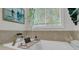 Inviting soaking tub with a brass faucet and an open window view at 2197 Sandy Point Ln, Mount Pleasant, SC 29466
