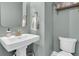 Elegant half bath featuring a modern pedestal sink, stylish fixtures, and calming color palette at 2197 Sandy Point Ln, Mount Pleasant, SC 29466
