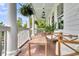 Inviting front porch with white columns, hanging ferns, comfortable seating, and a view of the lush surroundings at 2197 Sandy Point Ln, Mount Pleasant, SC 29466