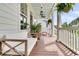 Cozy front porch with overhead fans, white columns, comfortable seating, and hanging ferns for relaxing outdoors at 2197 Sandy Point Ln, Mount Pleasant, SC 29466