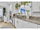 Kitchen with stainless steel appliances, granite countertops, white cabinets, and view into the living room at 2197 Sandy Point Ln, Mount Pleasant, SC 29466