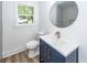 Bathroom featuring blue vanity, white sink, gold faucet, window, and toilet at 2219 Eagle Dr, North Charleston, SC 29406