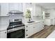 Updated kitchen with subway tile backsplash, stone countertops, stainless appliances, and stylish hardware at 2219 Eagle Dr, North Charleston, SC 29406