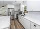 Bright kitchen features stainless steel appliances, white cabinets, stone countertops, and wood-look floors at 2219 Eagle Dr, North Charleston, SC 29406