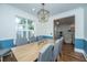 Bright dining room featuring a modern chandelier, hardwood floors, and a large window with plantation shutters at 2324 High Tide Dr, Charleston, SC 29414