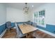 Cozy dining room showcases a modern chandelier, hardwood floors, and a large window with plantation shutters at 2324 High Tide Dr, Charleston, SC 29414