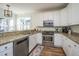 Well-lit kitchen features white cabinets, granite countertops, and stainless steel appliances at 2324 High Tide Dr, Charleston, SC 29414