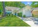 Traditional home with manicured lawn, lush landscaping, and mature trees at 2418 Tuscany Dr, North Charleston, SC 29406