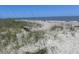 Dune view of beach with bench and people enjoying the ocean at 2604 Palmetto Blvd, Edisto Island, SC 29438