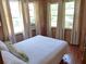 Bright bedroom with a full bed, wood floors, wood paneled walls, and natural light at 2604 Palmetto Blvd, Edisto Island, SC 29438