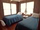 Twin beds in a wood-paneled bedroom illuminated by natural light, creating a cozy and inviting space at 2604 Palmetto Blvd, Edisto Island, SC 29438