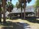 Charming coastal home elevated with a spacious deck, perfect for enjoying the surrounding palm trees and ocean breeze at 2604 Palmetto Blvd, Edisto Island, SC 29438