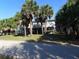 Coastal home on stilts surrounded by lush greenery, blending charm and nature at 2604 Palmetto Blvd, Edisto Island, SC 29438