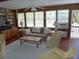 Cozy living room with wooden walls, a ceiling fan, built-in bookshelves, and ample natural light at 2604 Palmetto Blvd, Edisto Island, SC 29438