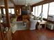 Spacious living room with hardwood floors, wood paneling, built-in shelving, and ample natural light at 2604 Palmetto Blvd, Edisto Island, SC 29438