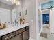 Bathroom featuring a gray vanity, mirror with lights and a sliding barn door leading to another room with a shower at 2827 Wagner Way, Mount Pleasant, SC 29466