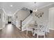 Bright dining area with light wood floors, white trim, and a view of the front entryway and staircase at 2827 Wagner Way, Mount Pleasant, SC 29466