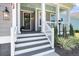 Inviting front porch with a lantern, potted flowers and manicured landscaping at 2827 Wagner Way, Mount Pleasant, SC 29466