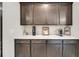 Close-up view of dark wood kitchen cabinets with modern hardware and a decorative backsplash at 2827 Wagner Way, Mount Pleasant, SC 29466